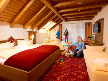 Eine Familie macht es sich in einem Hotelzimmer gemütlich