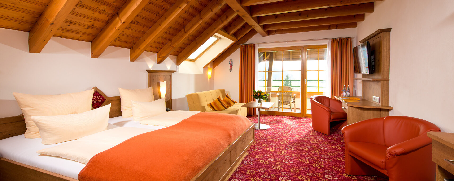 Gemütliches und einladendes, in rot gehaltenes Hotelzimmer des Hotel Silberkönig im Schwarzwald mit moderner Ausstattung.