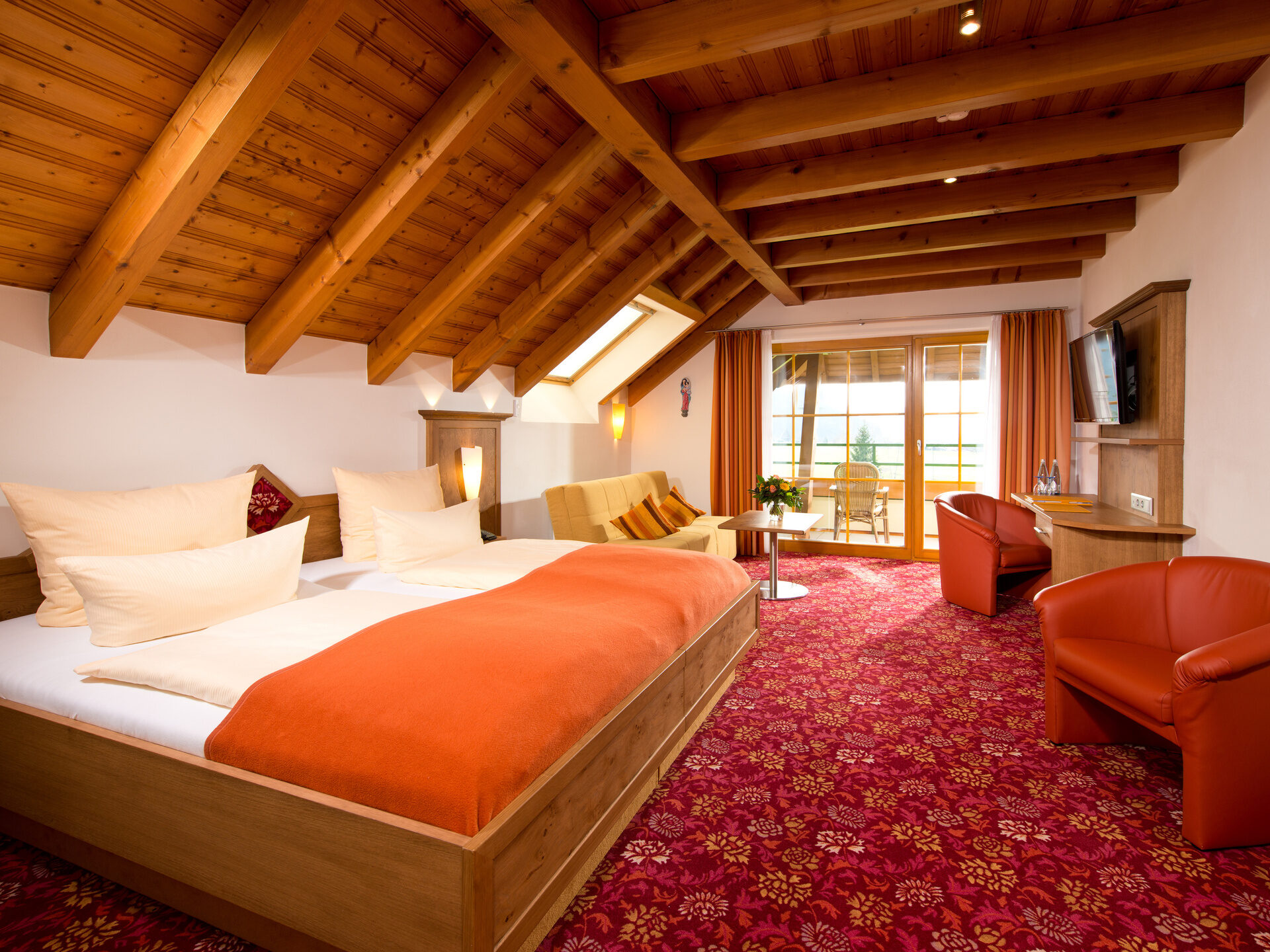 Gemütliches und einladendes, in rot gehaltenes Hotelzimmer des Hotel Silberkönig im Schwarzwald mit moderner Ausstattung.