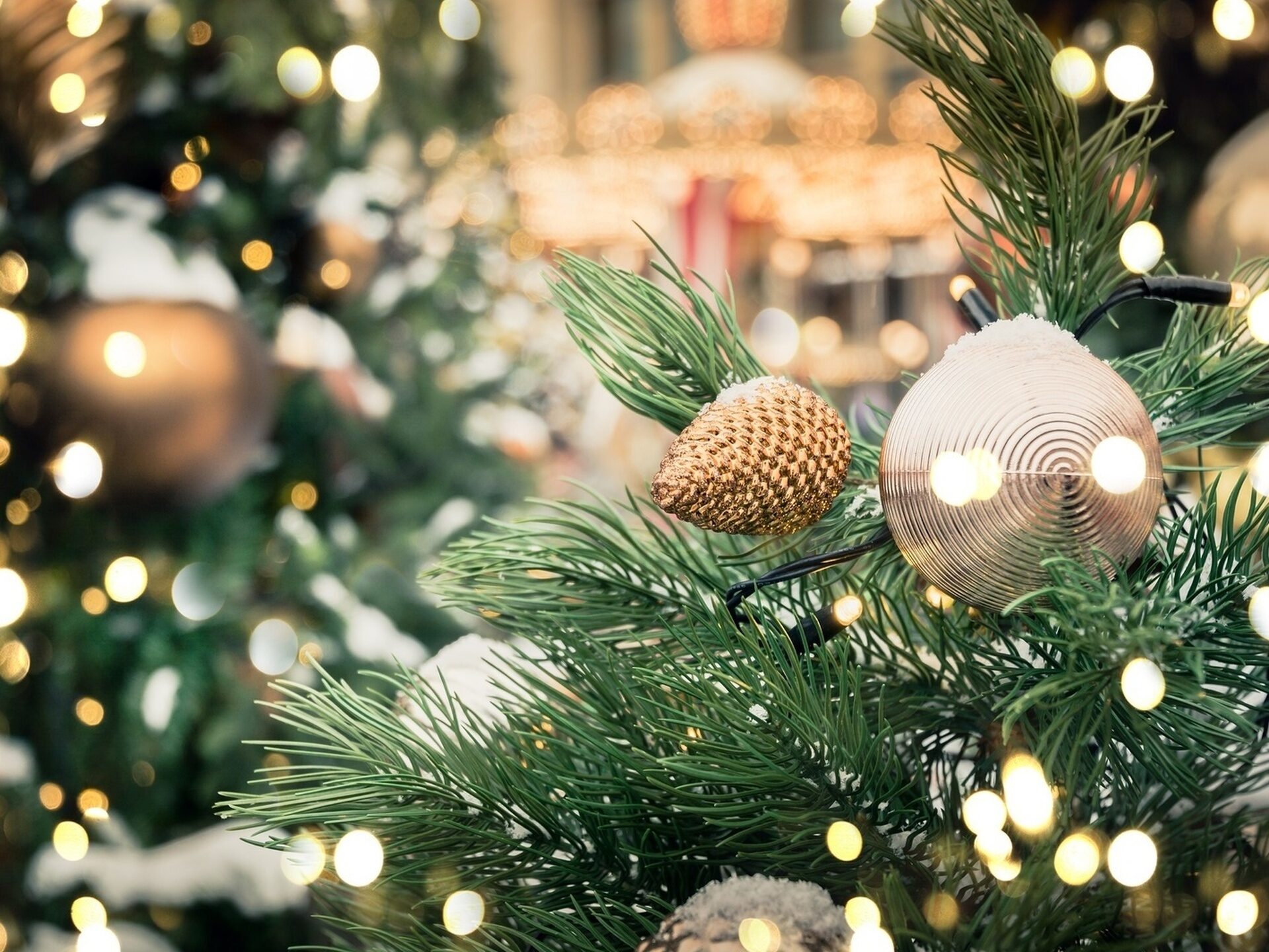 Ein Weihnachtsbaum ist hell erleuchtet und mit reichlich Deko geschmückt